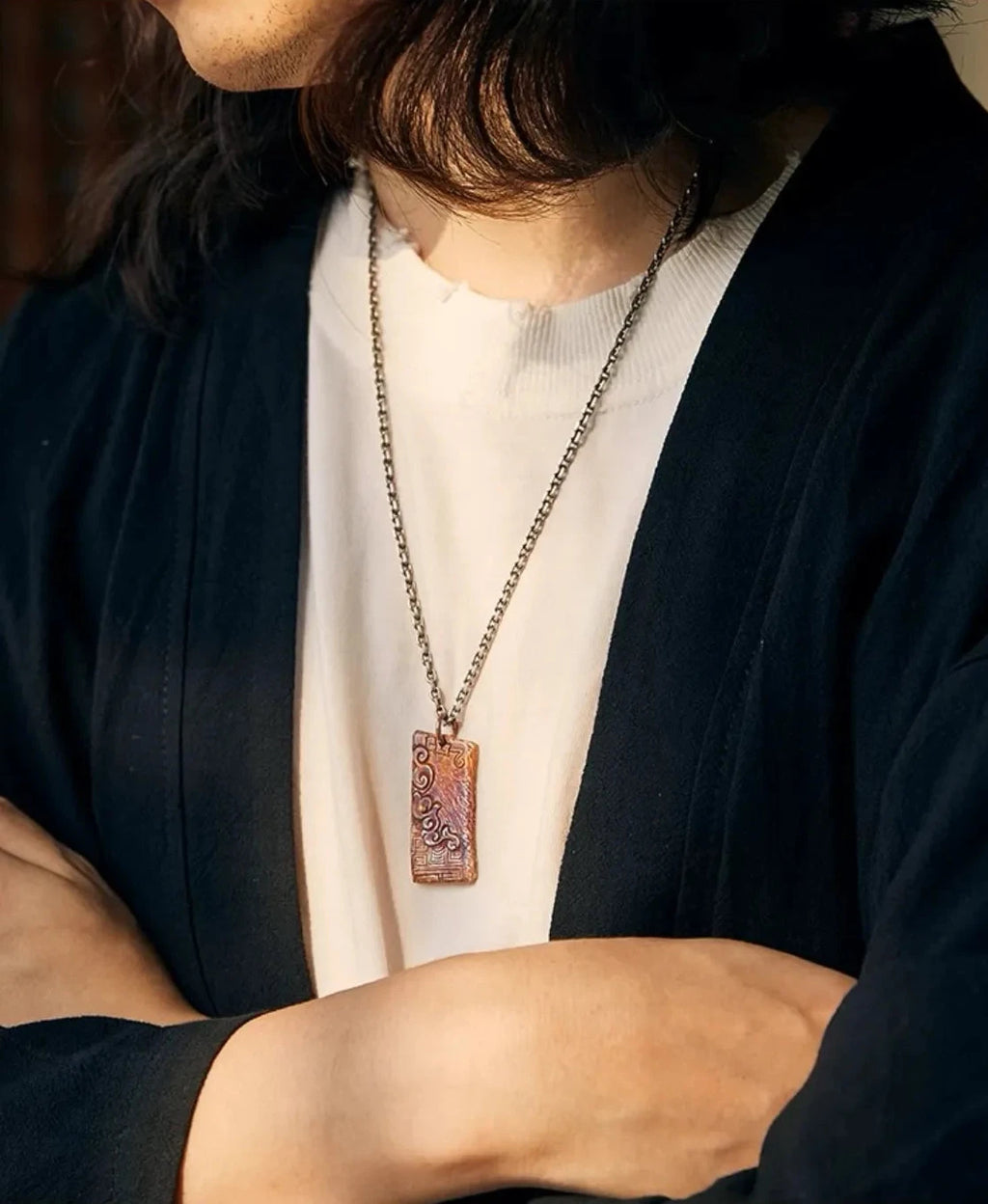 Model with arms crossed wearing the vintage-style rufous necklace, showing the pendant length and fit