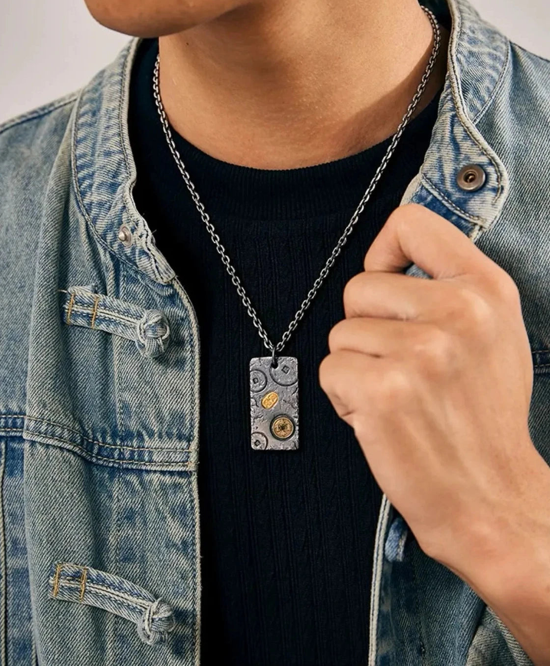 Model wearing the ancient coin and ingot necklace styled with a denim jacket and black shirt