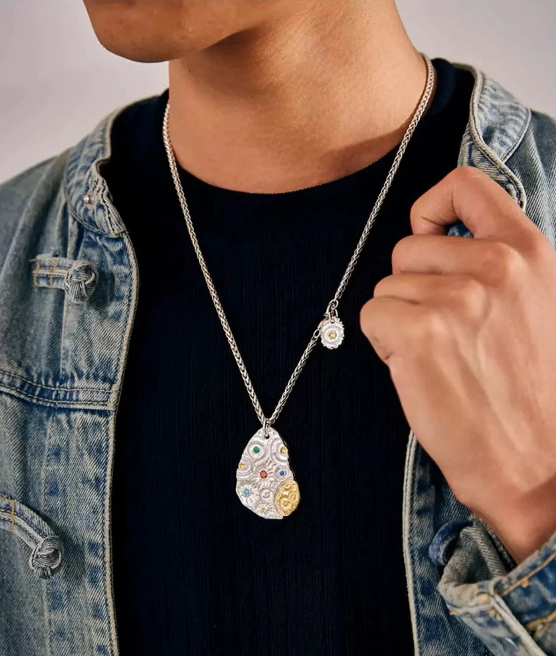 Stylish shot of a model wearing the Starway necklace with a denim jacket, highlighting the silver and gold details