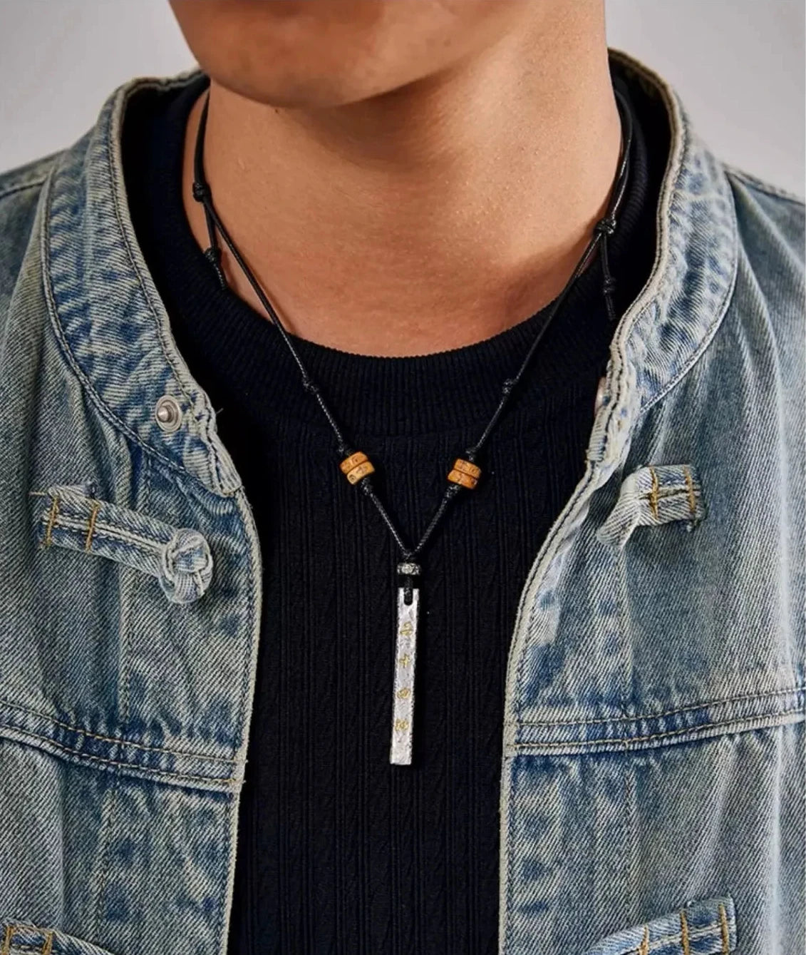 Model wearing the Taoist silver pendant necklace styled with a denim jacket and yak bone beads