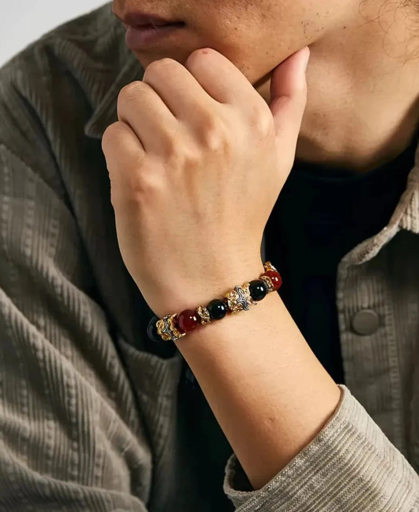 Lifestyle shot of a man in a corduroy shirt wearing the Taotie bracelet, blending traditional symbolism with modern casual style