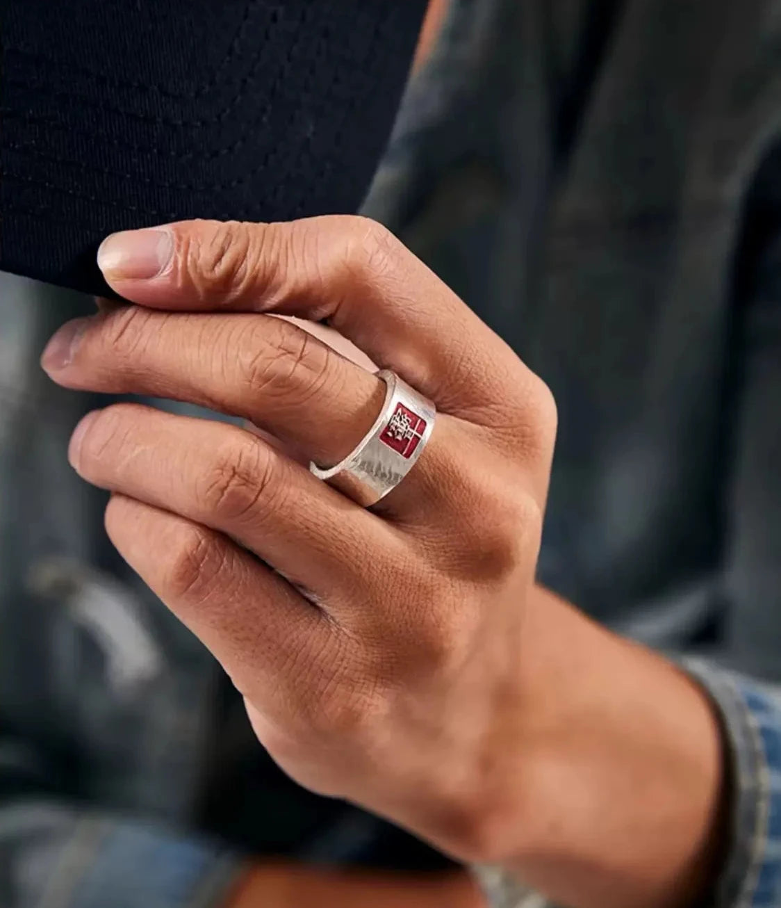 A trendy pose adjusting a baseball cap, showcasing the ring as a statement piece that merges traditional Taoist symbols with contemporary fashion