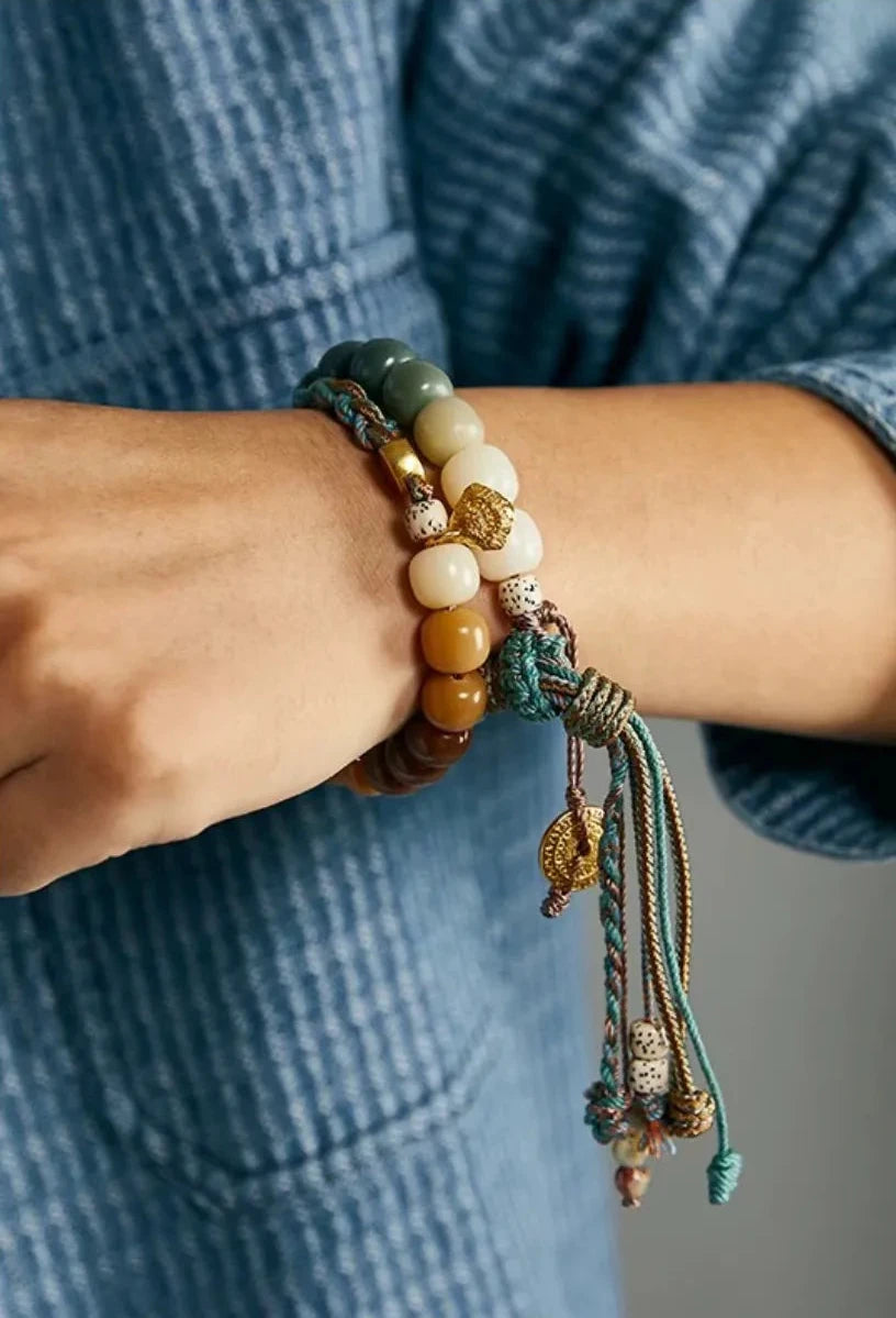 Close-up on the wrist showing the smooth texture of the jade and seed beads against the skin