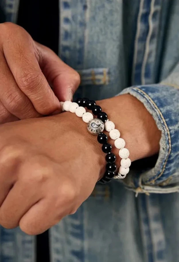 Close-up of the bracelets on the wrist, showing the shiny black obsidian beads against the skin