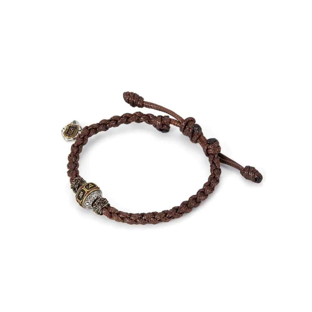 Side profile showing the detailed relief of the mantra characters on the oxidized silver tube bead