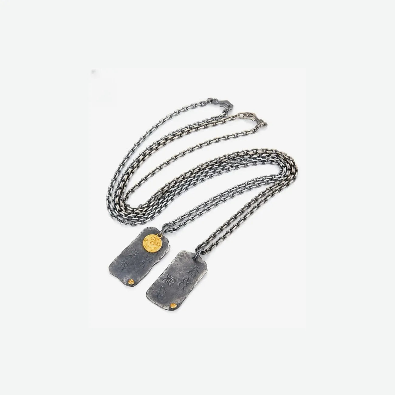 Flat lay of the Eternal Joy necklace with oxidized silver chains and vintage golden bronze elements