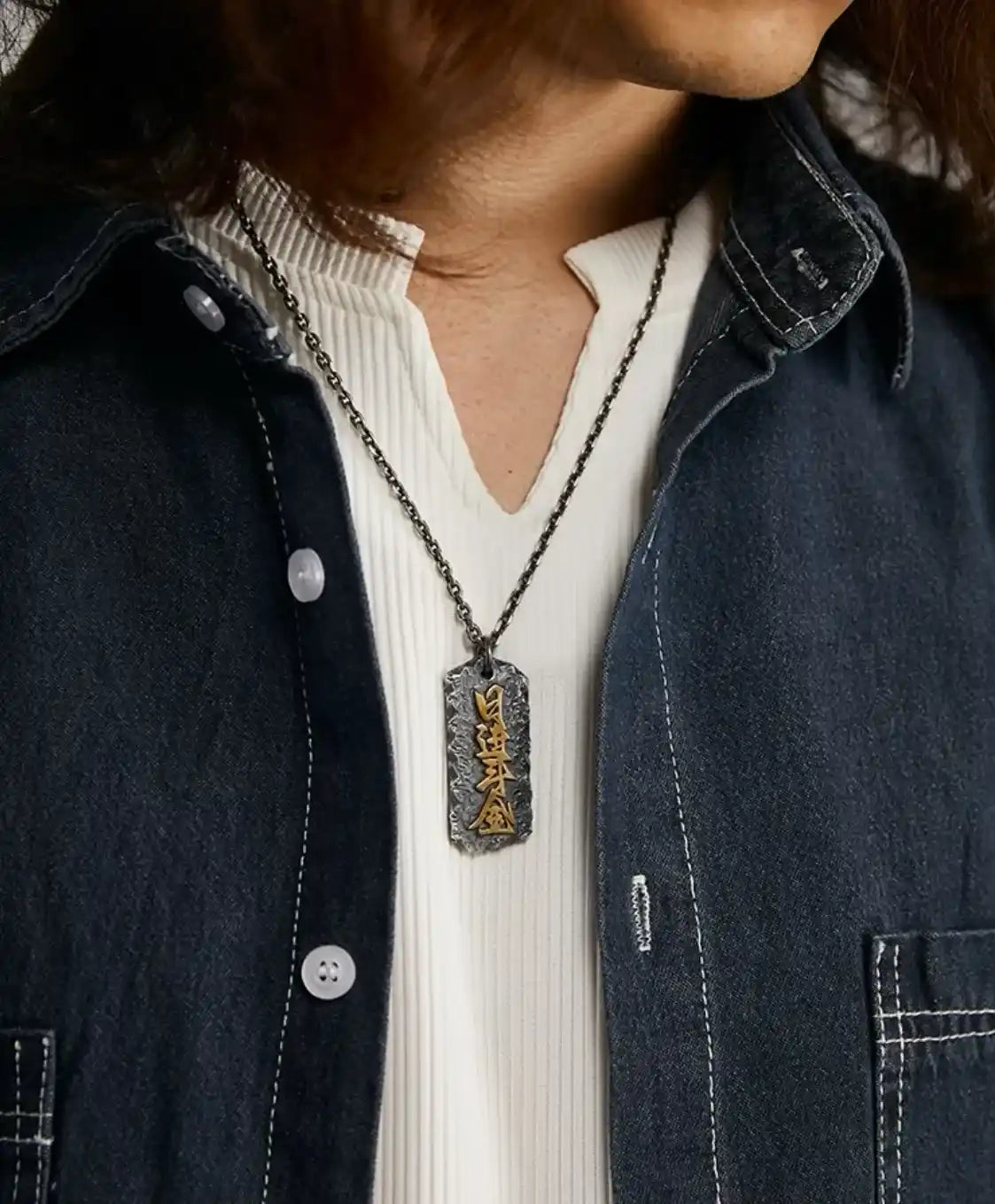 Model wearing the Abundance necklace with a denim shirt, showcasing the pendant's length and style