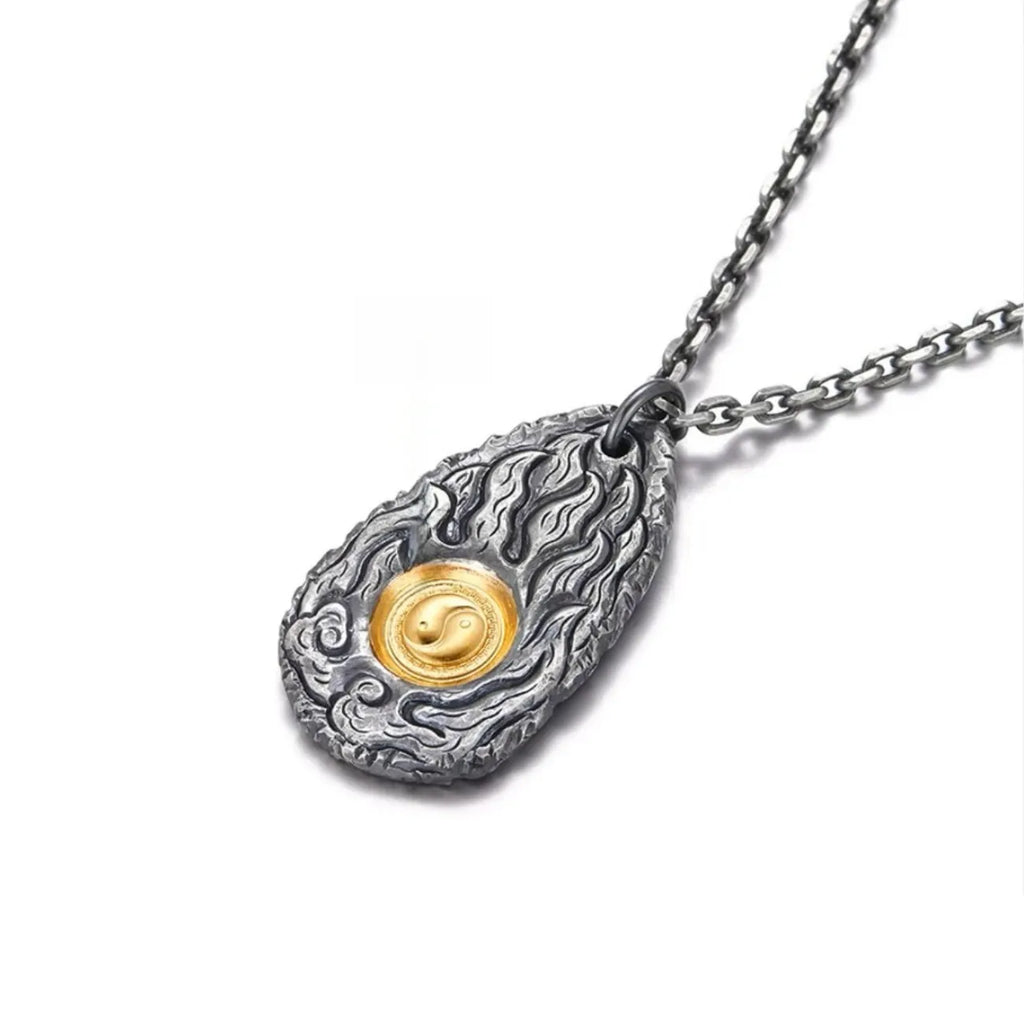 Angled shot showing the depth of the flame carvings and the contrast between the dark silver and bright gold center