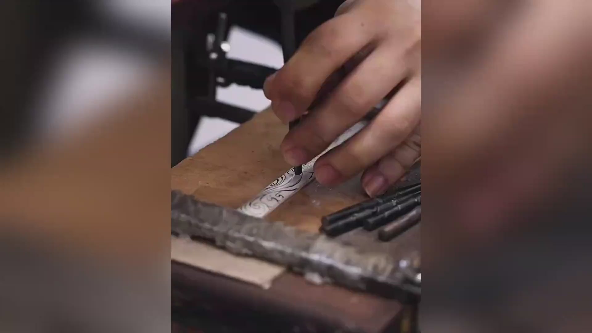 A silversmith handcrafts a koi fish silver bracelet. The video shows the entire process: shaping the symbolic carp, applying an antique patina for depth, and meticulously inlaying pure gold leaf solely into the fish's eye, bringing the motif to life.