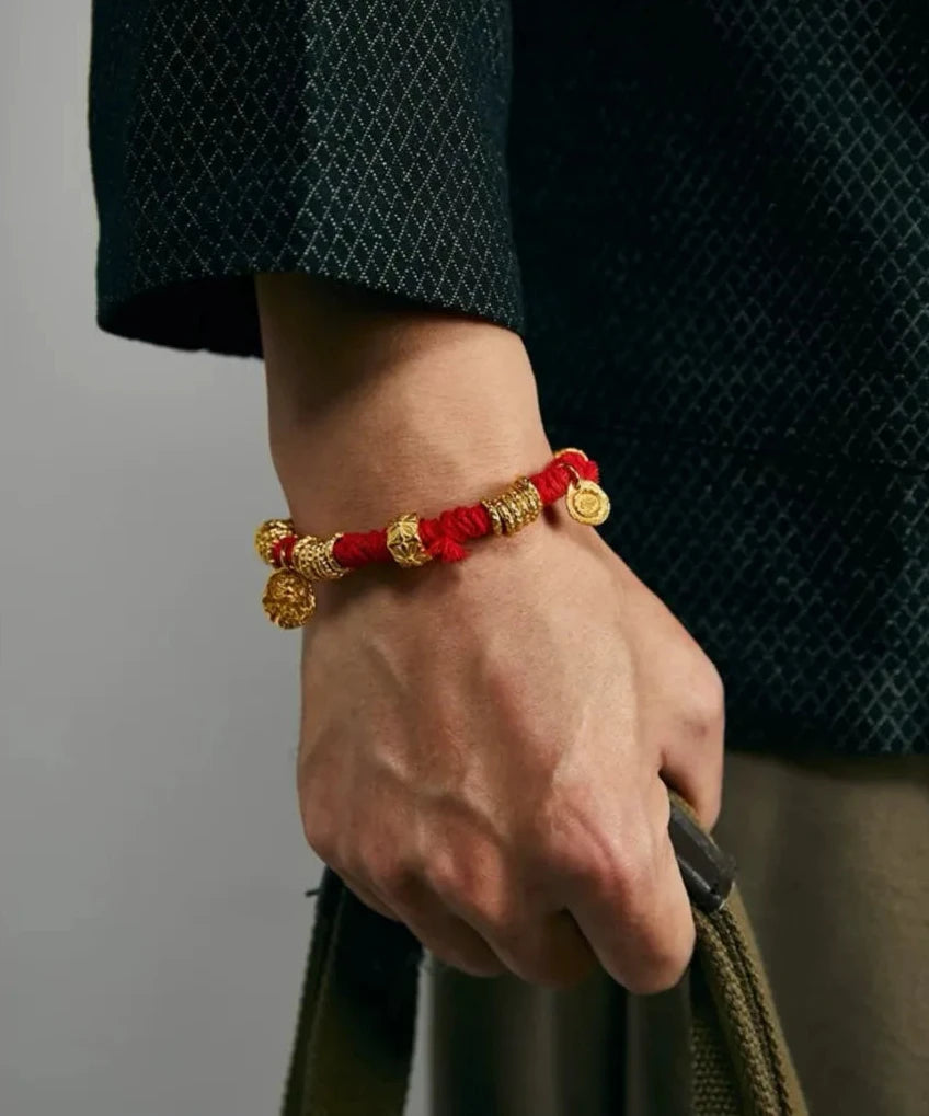 Lifestyle shot showing how the bright red bracelet pops against a dark textured jacket, adding a bold accent