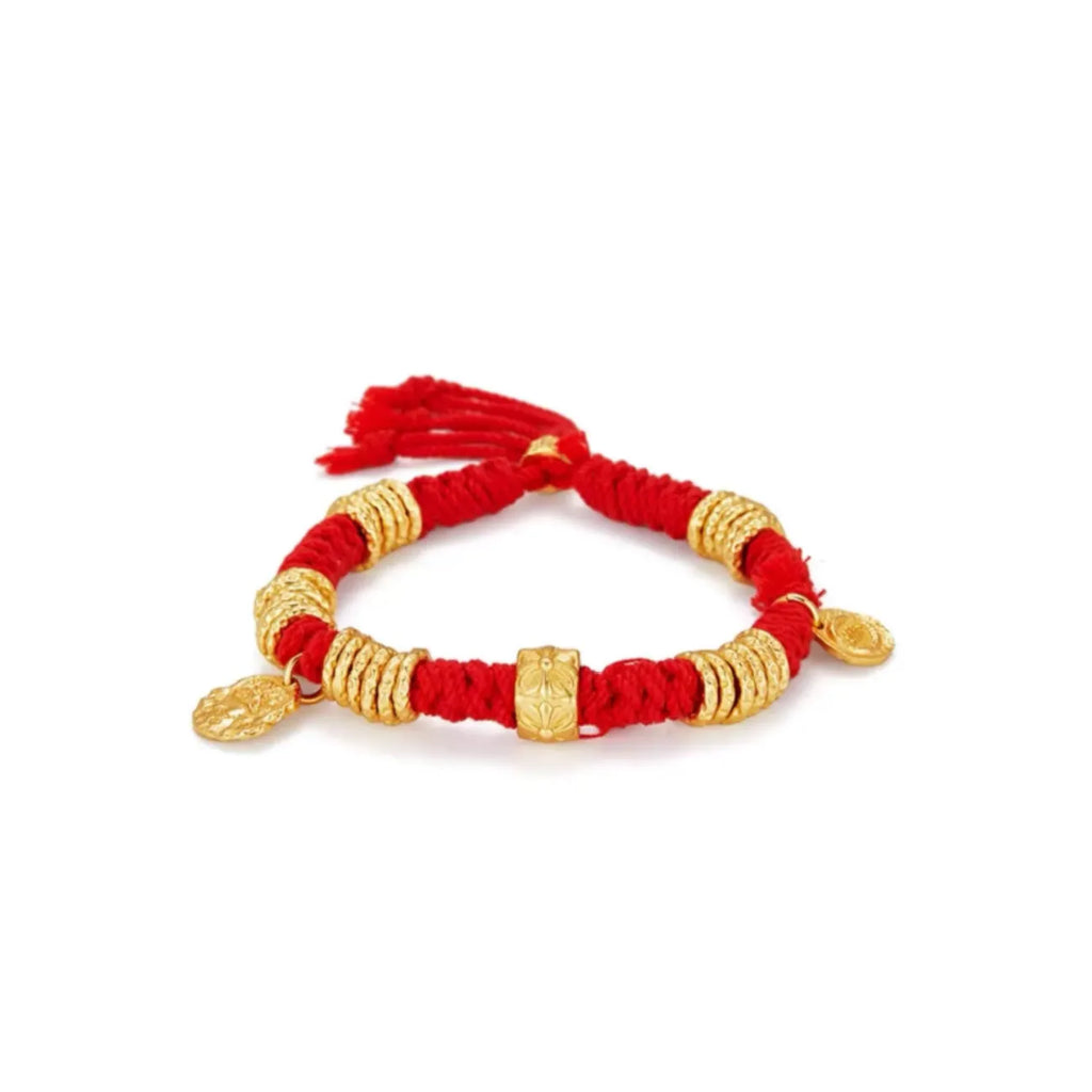 Front view of the chunky red cotton bracelet adorned with matte gold coils and lucky coin charms