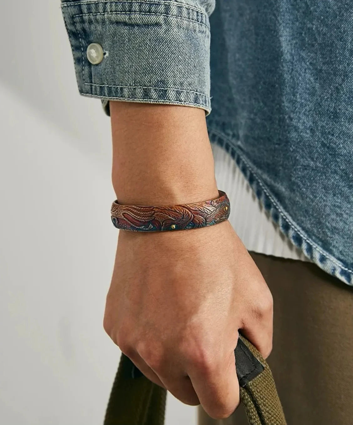 A moody portrait of a model wearing the phoenix bangle, evoking a sense of ancient mythology and modern retro fashion