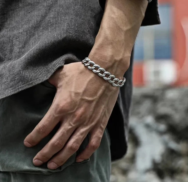 A masculine pose with hand in pocket, showcasing the bracelet's substantial weight and oxidized finish