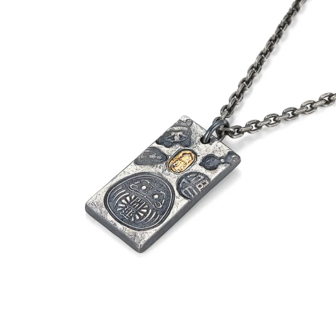 Angled shot of the silver fortune necklace showing the relief details of the Daruma doll and golden seal
