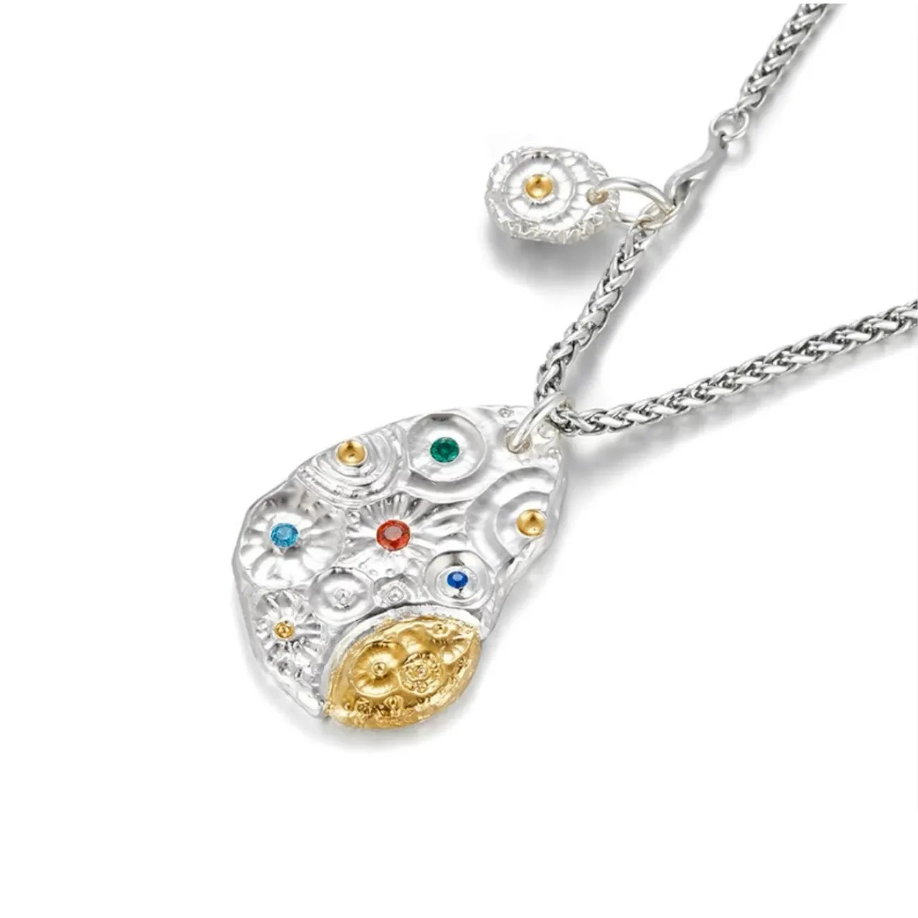 Angled shot of the Starway pendant showing the textured silver surface, gold accent, and colorful stones