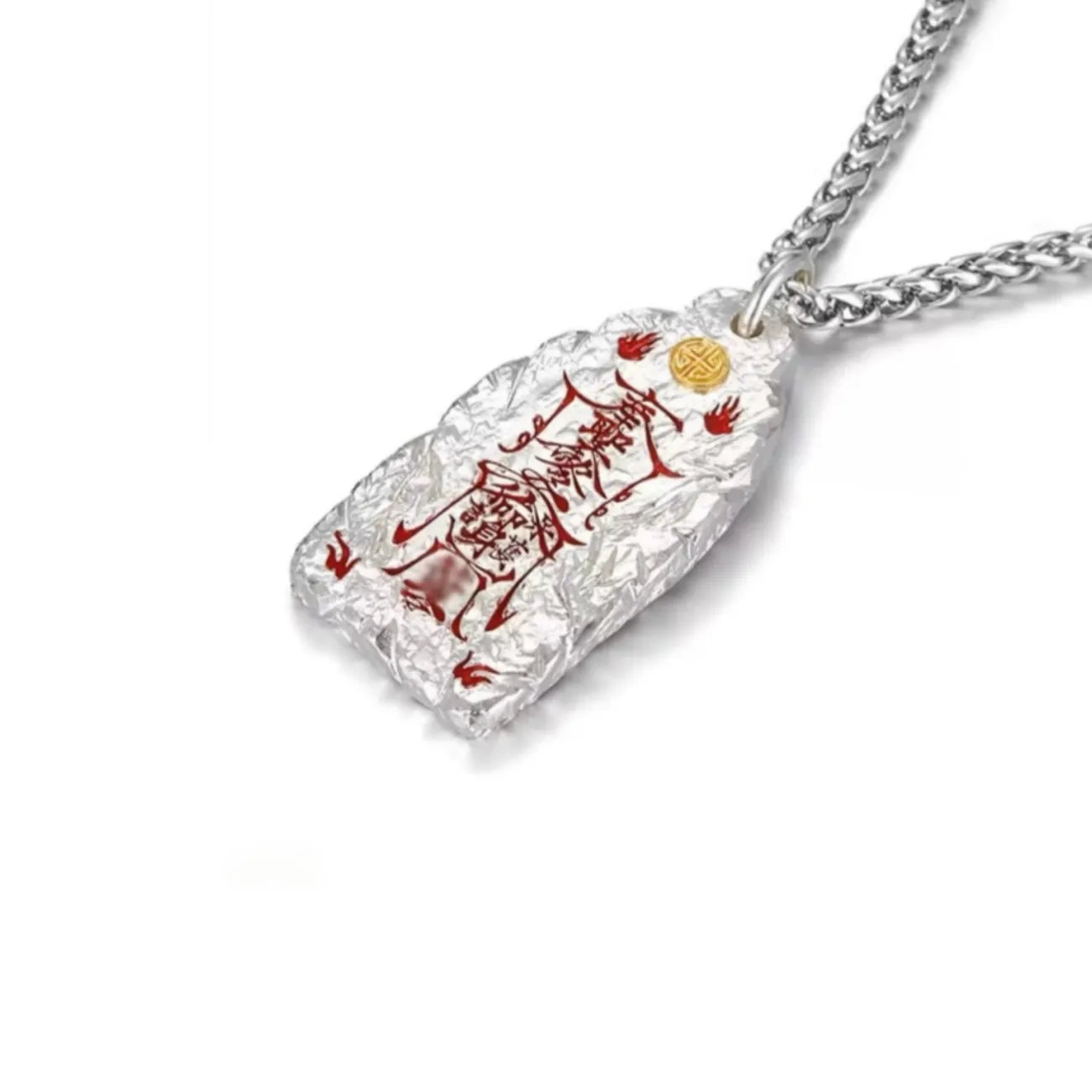 Angled side view of the silver Taoist pendant showing the thick textured metal and cinnabar inscription