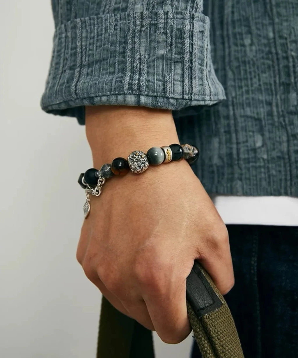 Close-up on the wrist highlighting the detailed silver Pixiu and the silky sheen of the Blue Tiger's Eye beads against the skin