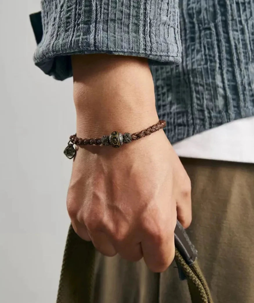 Lifestyle shot of the mantra bracelet paired with a canvas bag, perfect for the adventurous and mindful traveler