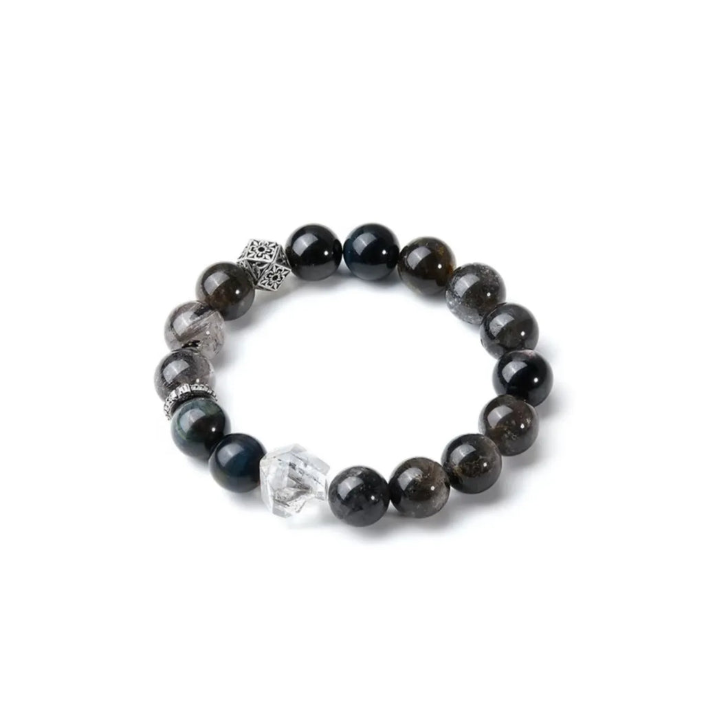Side profile showing the smooth polish of the dark stone beads contrasting with the rugged texture of the center crystal