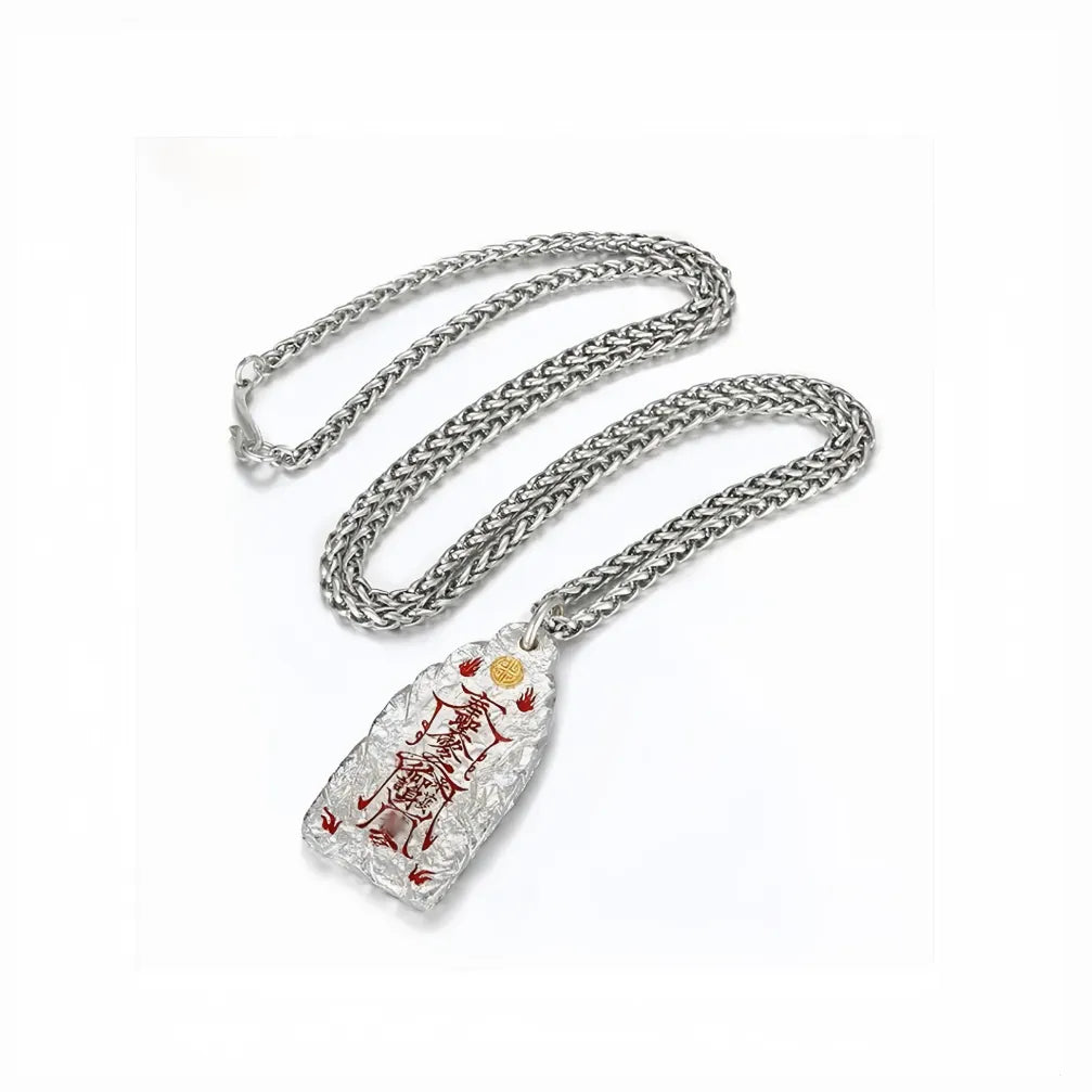 Flat lay of the sterling silver Taoist talisman necklace with the chain neatly coiled above