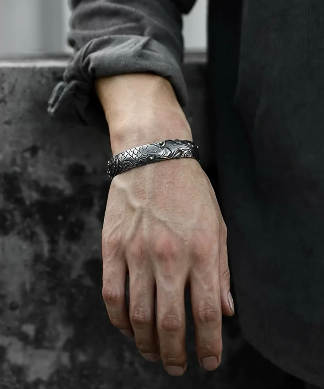 Close-up of clasped hands, focusing on the carp bangle as a symbol of perseverance, success, and good fortune