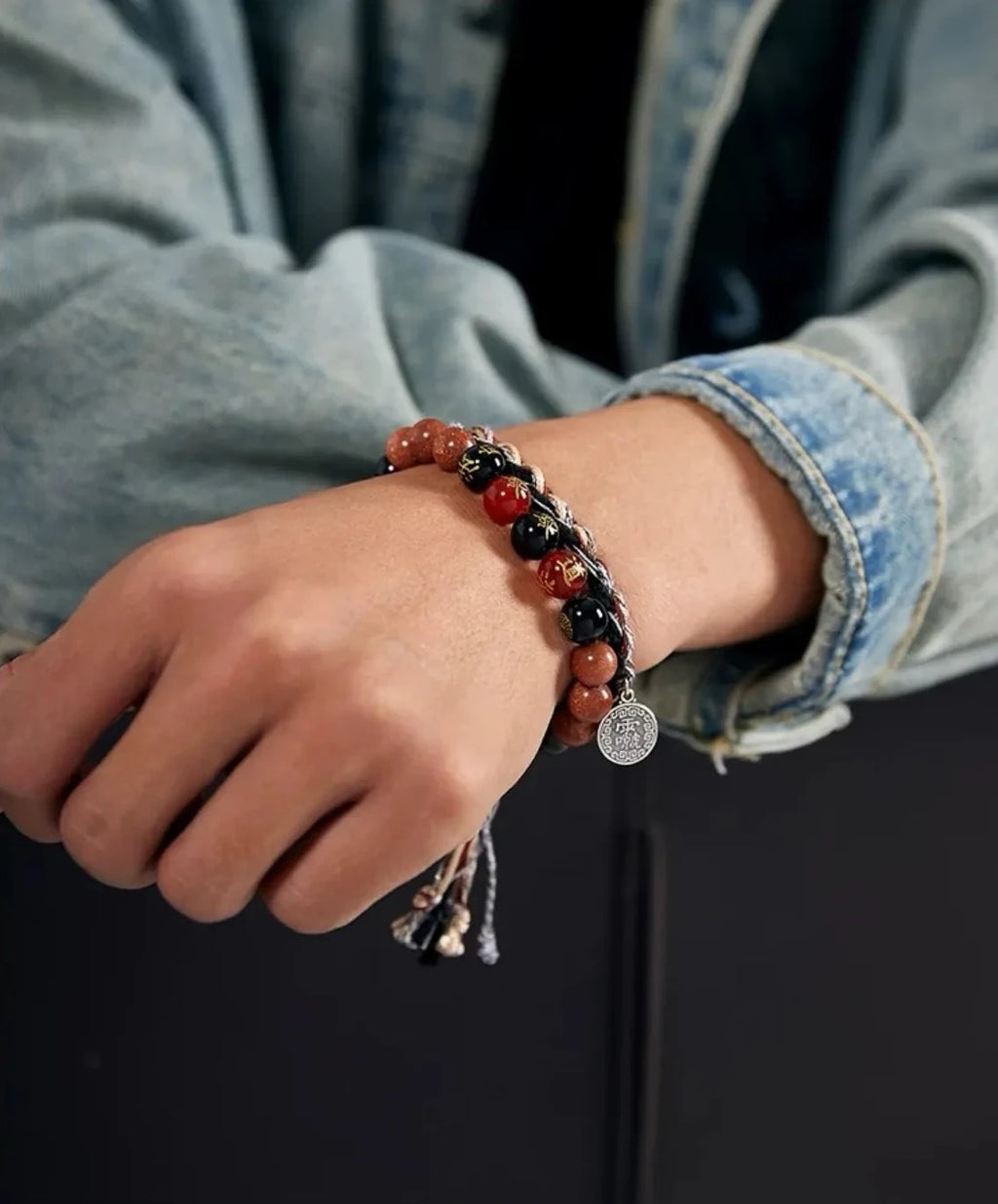 A focused shot of the silver Bagua charm hanging from the wrist, symbolizing balance and protection against negative energy