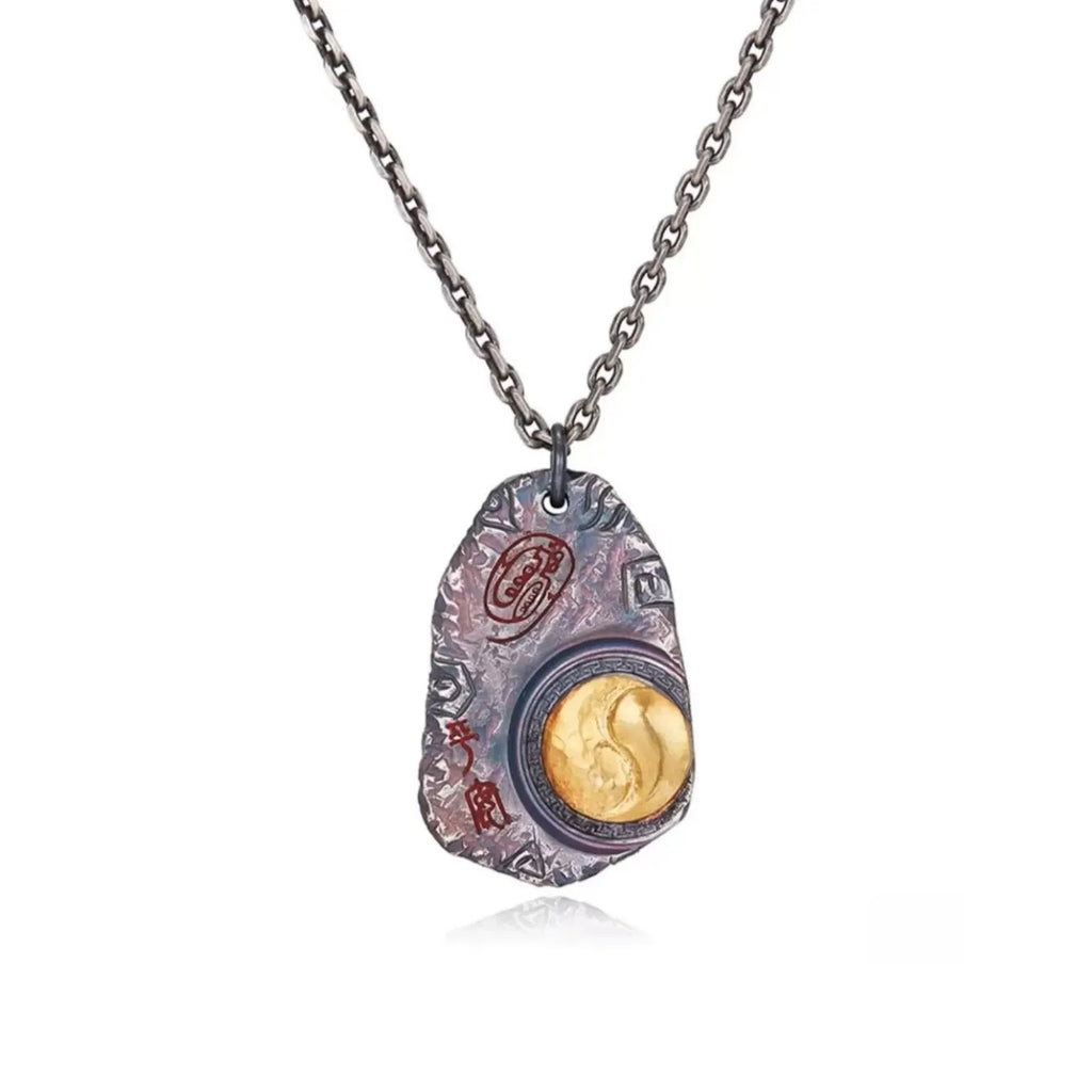 Front view of the Taichi necklace featuring a silver tag with a gold Yin Yang symbol and rugged texture