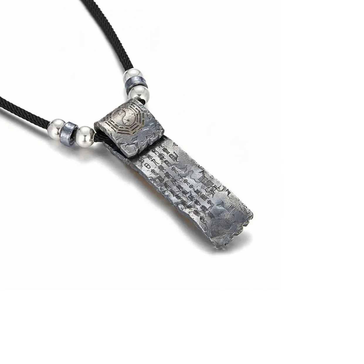 Back of the protection charm displaying the Yin Yang symbol and engraved scripture