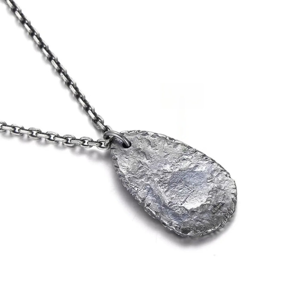 Back view of the pendant displaying a rugged, hammered silver texture