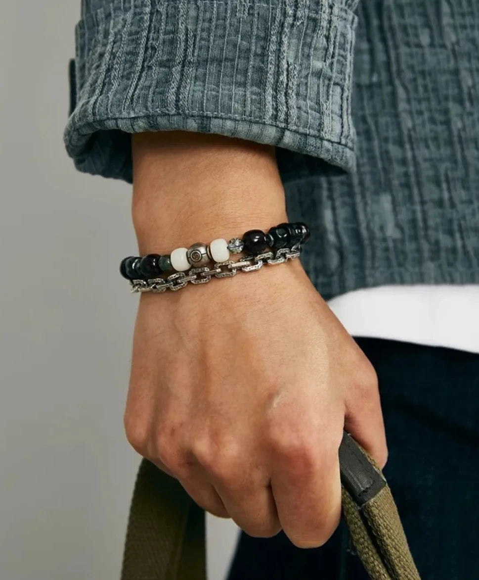 Lifestyle shot of a man holding a bag, showing how the silver chain drapes stylishly alongside the Bodhi beads