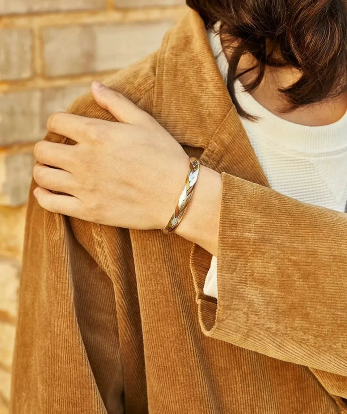 A model wearing the mixed metal cuff, demonstrating its versatile size and how it complements warm-toned autumn fashion