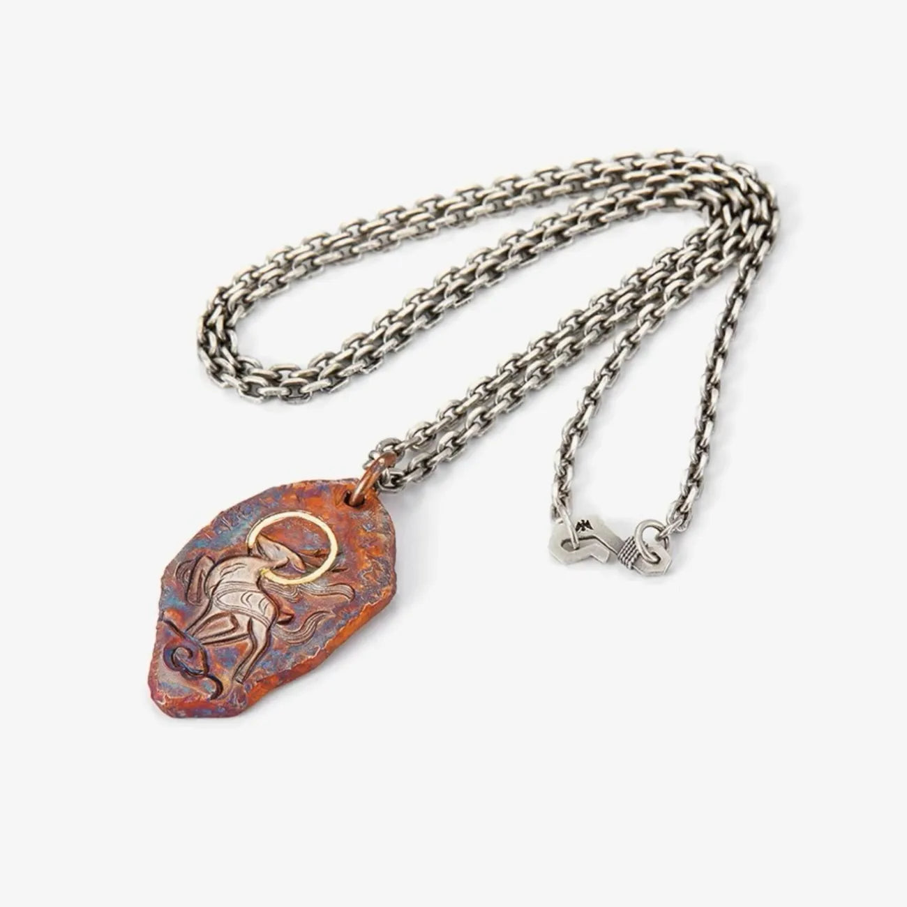 Flat lay of the vintage-style Celestial Stag necklace with silver and gold accents