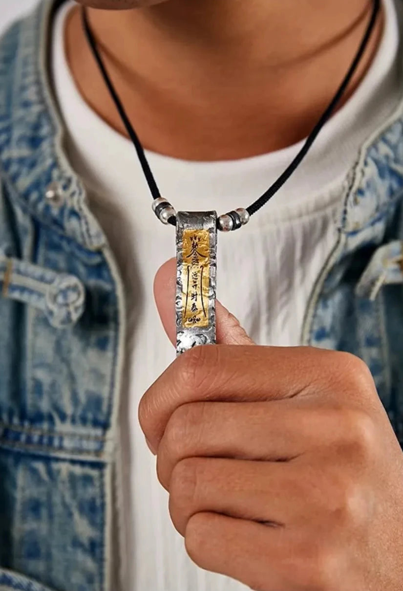 Close-up of vintage style Taoist jewelry worn over a white t-shirt